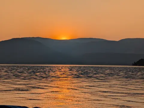 Orange sun setting behind the hills, Okanagan Lake at Okanagan Landing, Vernon, B.C., September 3, 2025